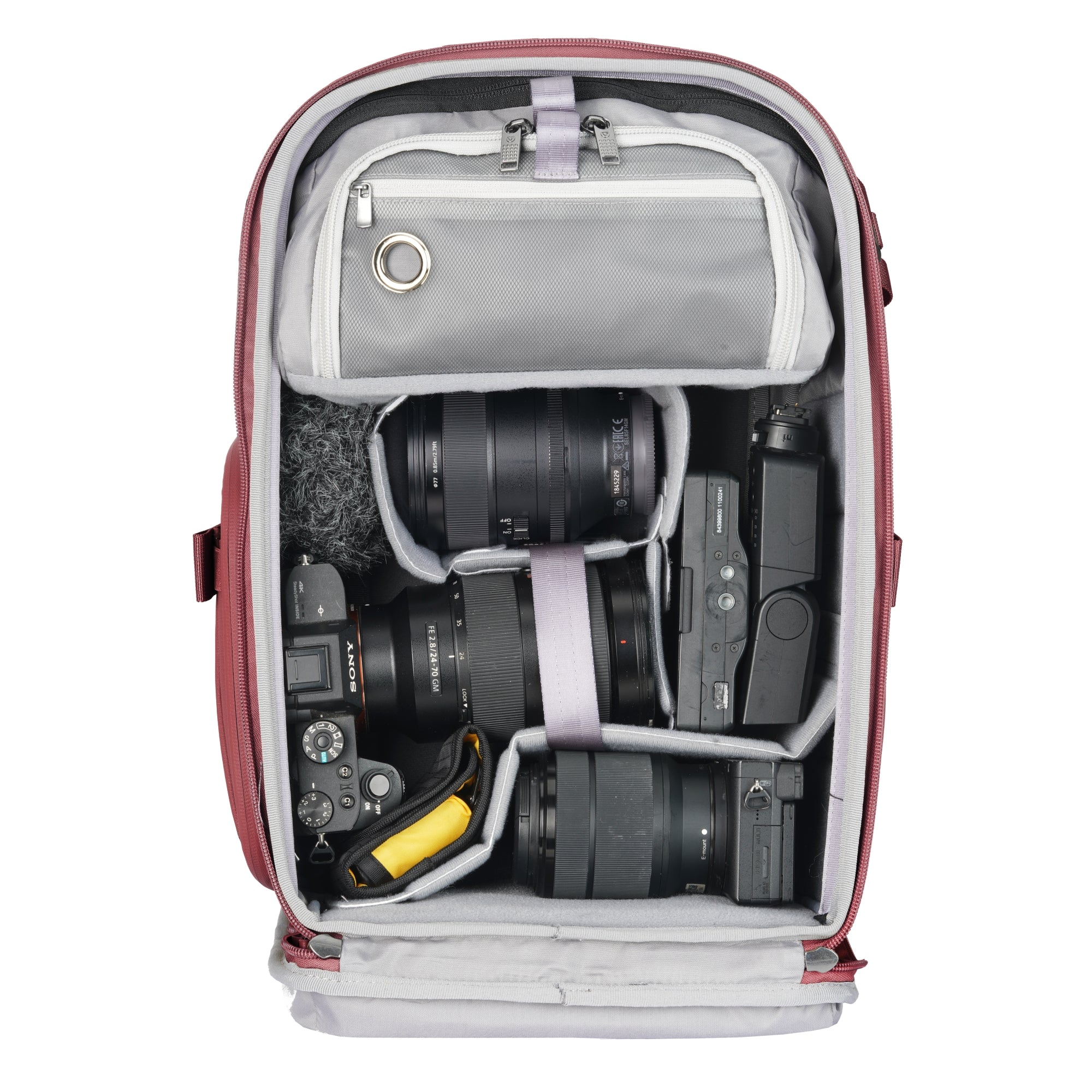 Ein geöffneter, roter Rucksack mit Kameras und Objektiven.