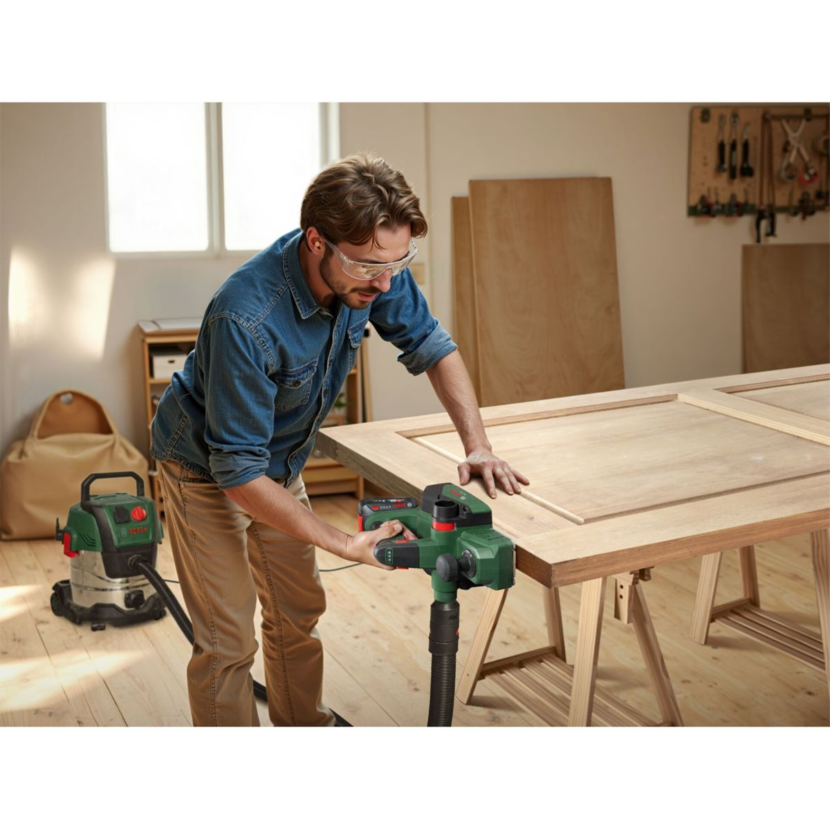 Ein Mann in einer Werkstatt benutzt einen Hobel an einer Holztür.