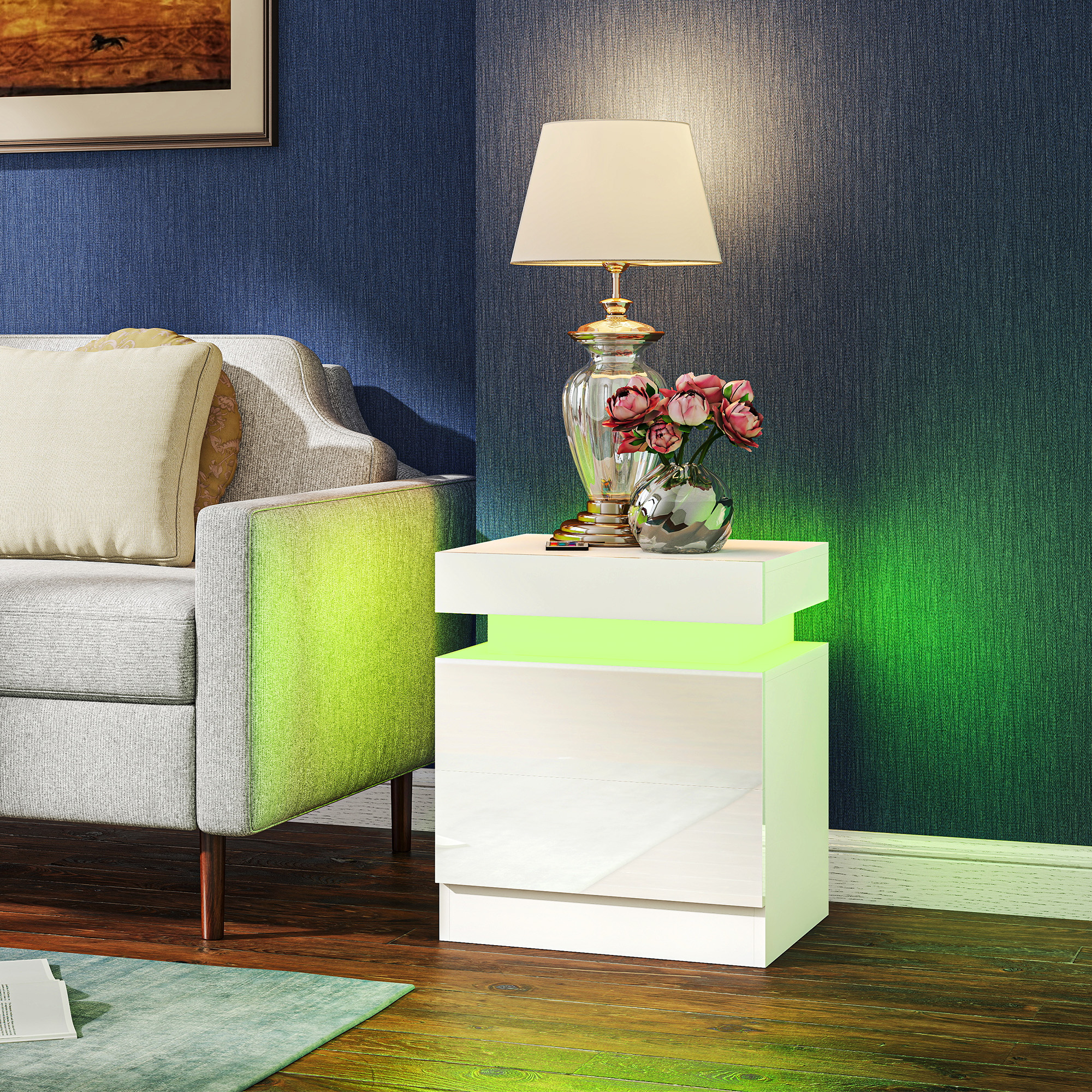 Un comodino bianco con illuminazione LED verde accanto a un divano grigio.