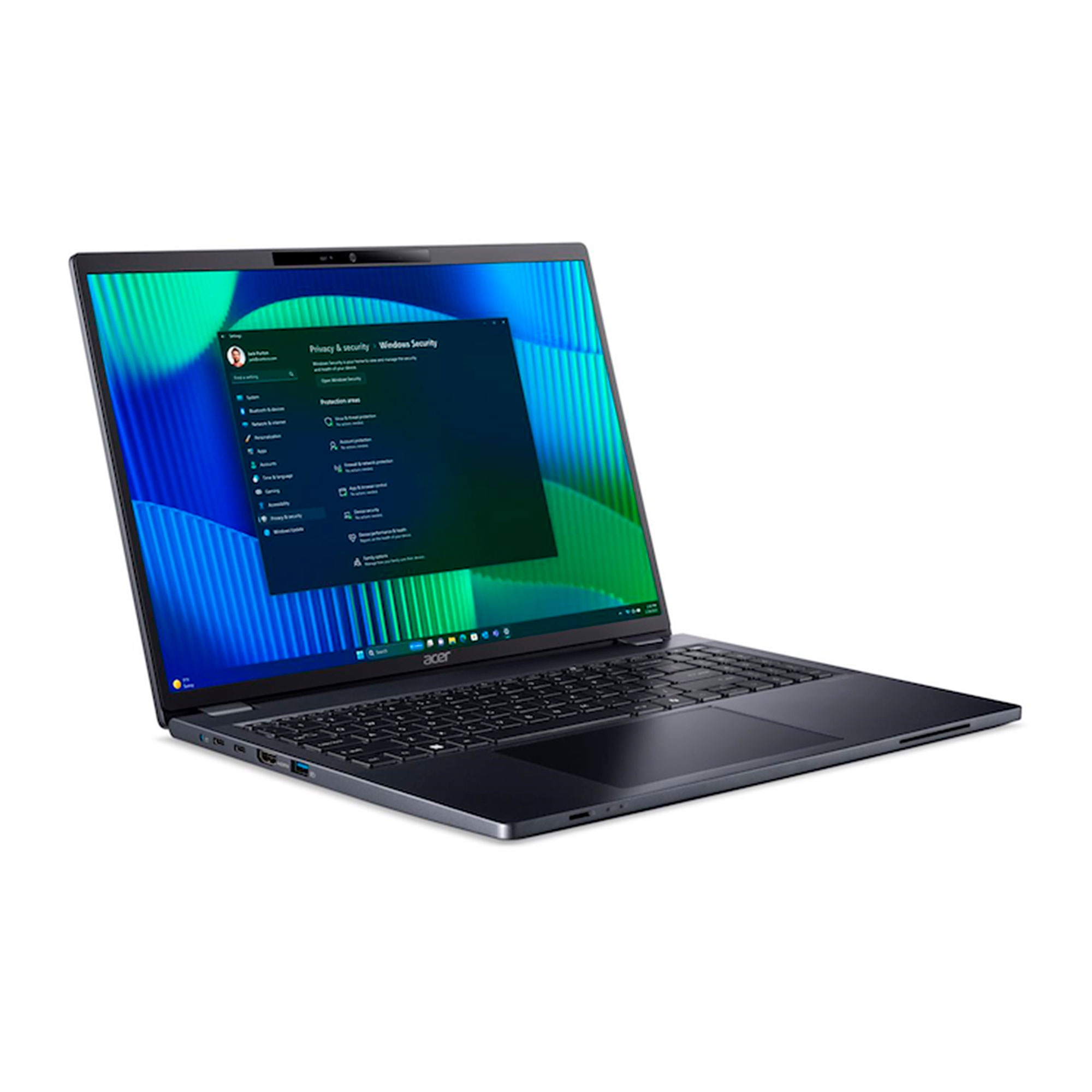 Un portátil oscuro abierto muestra un fondo de pantalla azul y verde. La ventana de Seguridad de Windows está abierta.