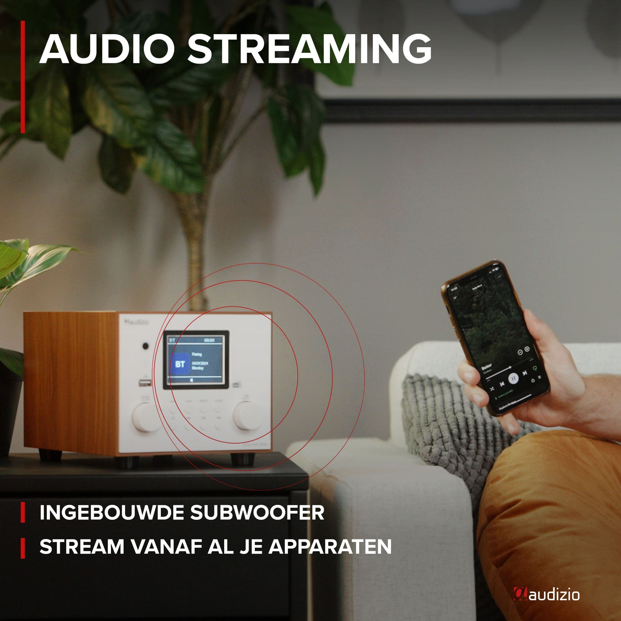 Een man houdt een smartphone naast een houten Hi-Fi apparaat met display.