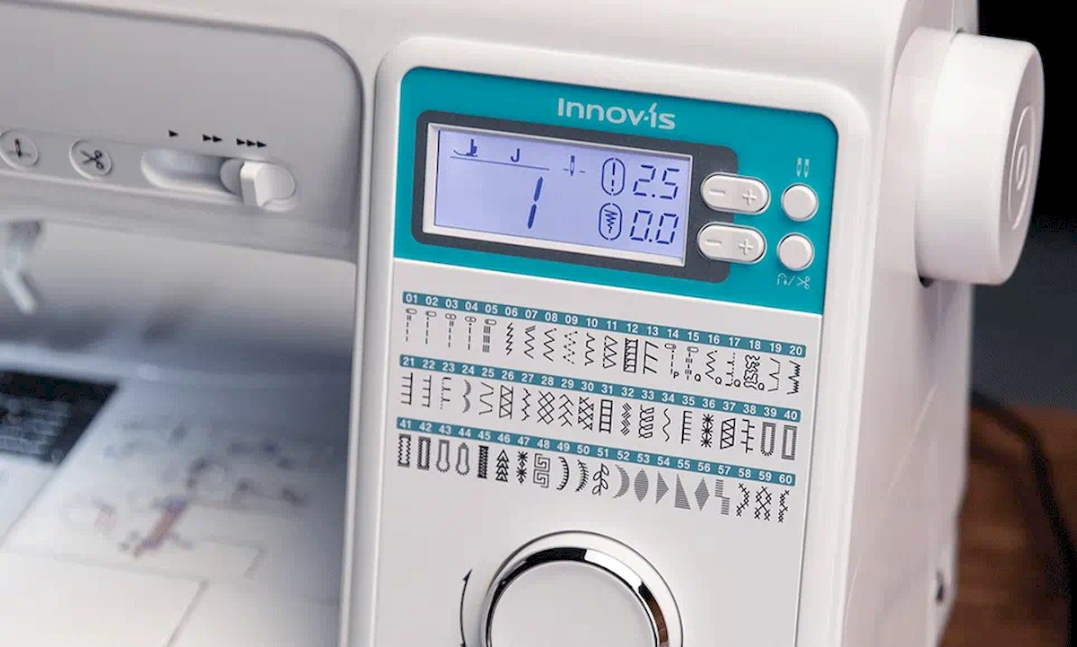 Sewing machine control panel with stitch selection, display and buttons.