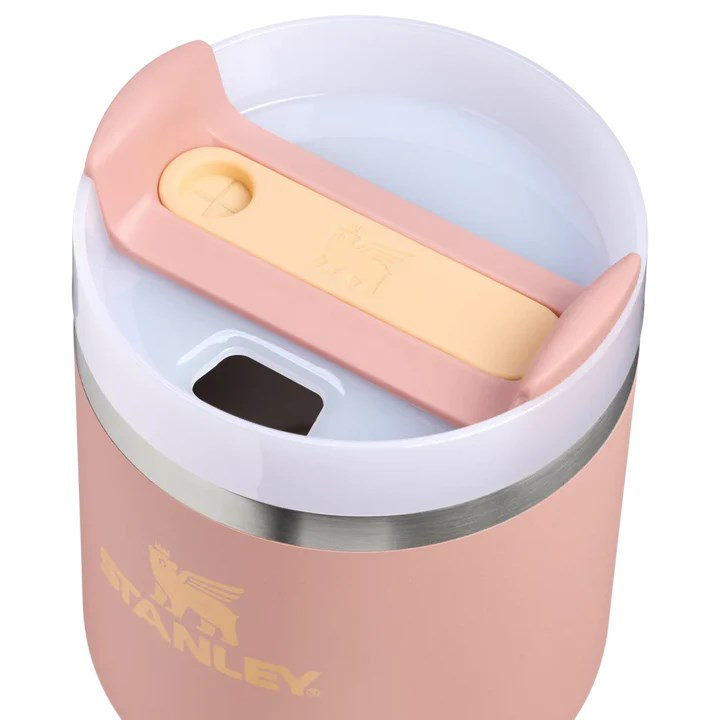 Gümüş kenarlı ve sarı sürgülü kapaklı pembe Stanley bardak.