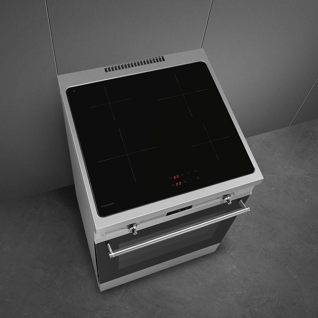 Un piano cottura a induzione moderno con superficie nera e forno argentato.