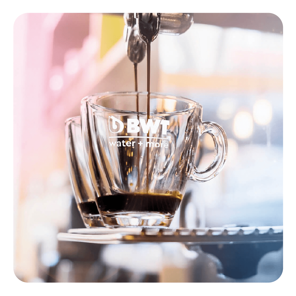 L'espresso viene versato in una tazza trasparente con logo BWT.