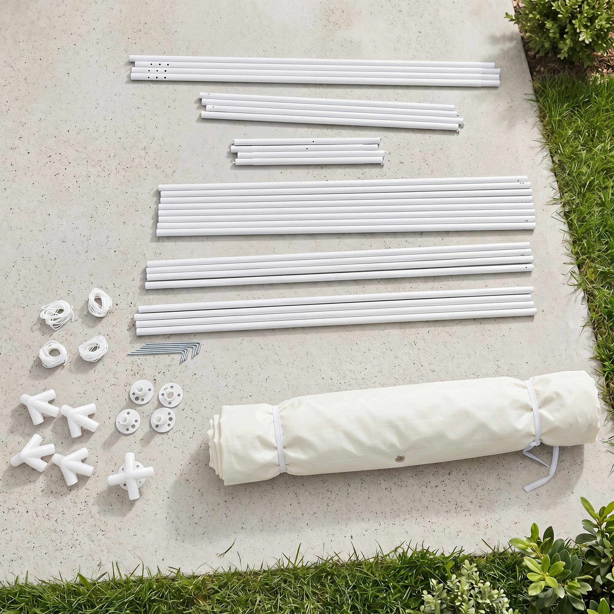 Varillas blancas, conectores, cuerdas y tela crema enrollada sobre concreto.