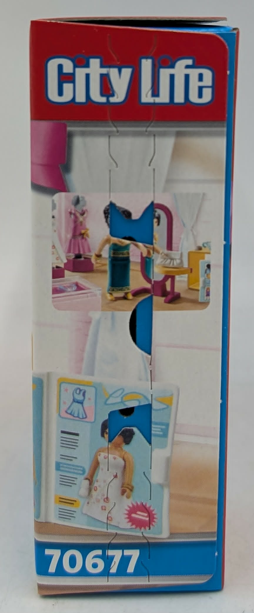 Spielzeugverpackung mit Figuren: Eine Puppe vor einem Spiegel, eine Puppe in einem Kleid.