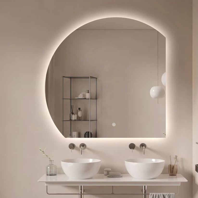 A modern bathroom with two sinks, a large backlit mirror, and a metal shelf.