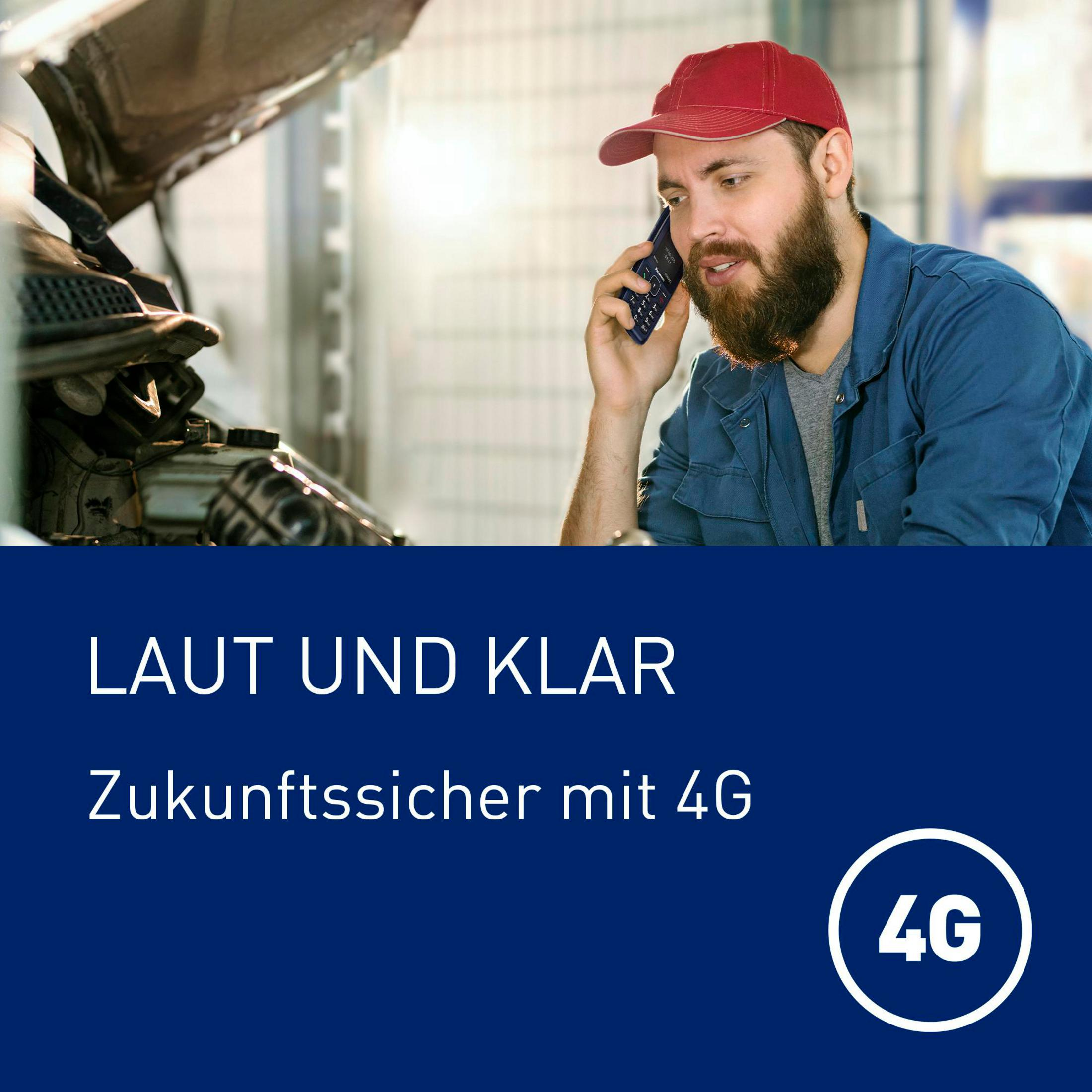 Meccanico con cappellino rosso parla al telefono davanti al cofano aperto.