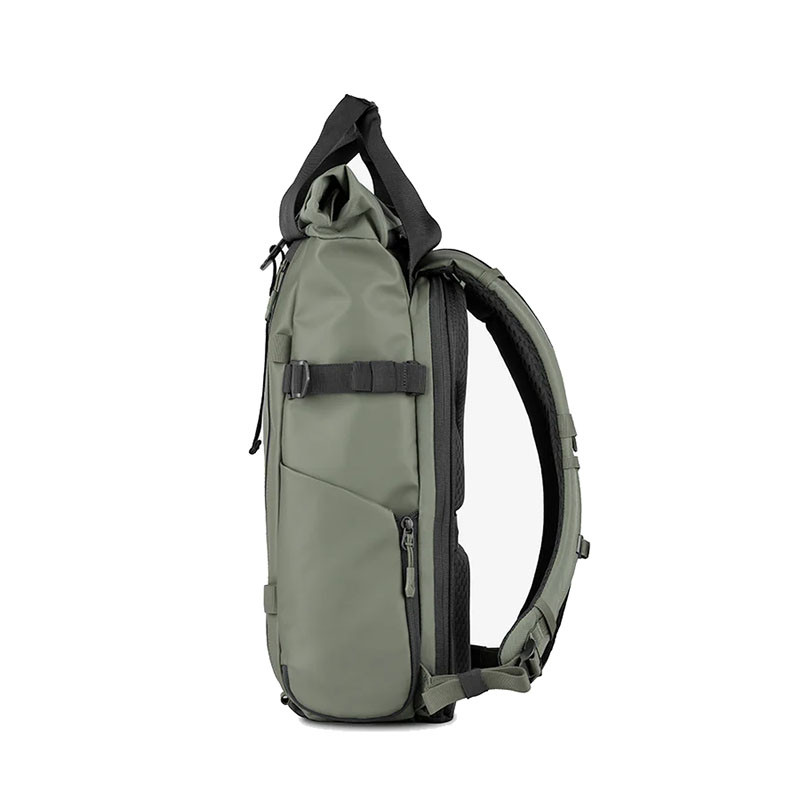 An olive green bag with black straps and zippers against a white background.