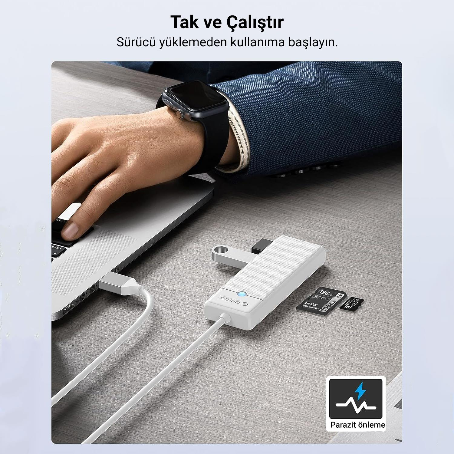 Bir laptop beyaz bir hub'a bağlı, yanında hafıza kartları var.