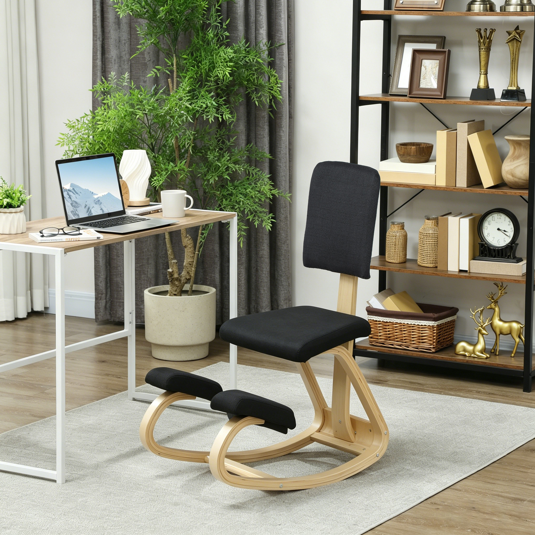 Una silla ergonómica de rodillas está frente a un escritorio con laptop y plantas.