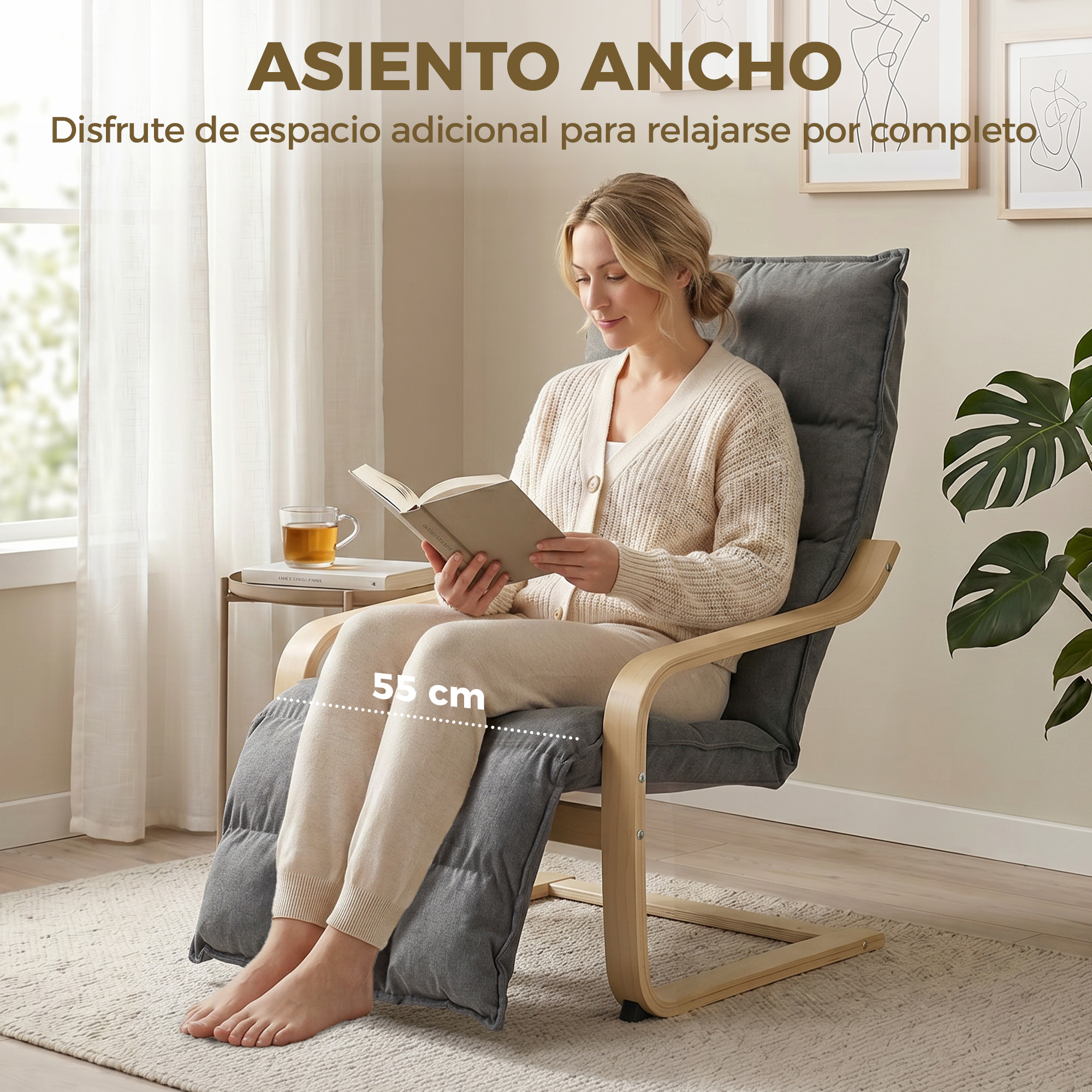 Una mujer lee en un sillón gris ancho con reposapiés y marco de madera.