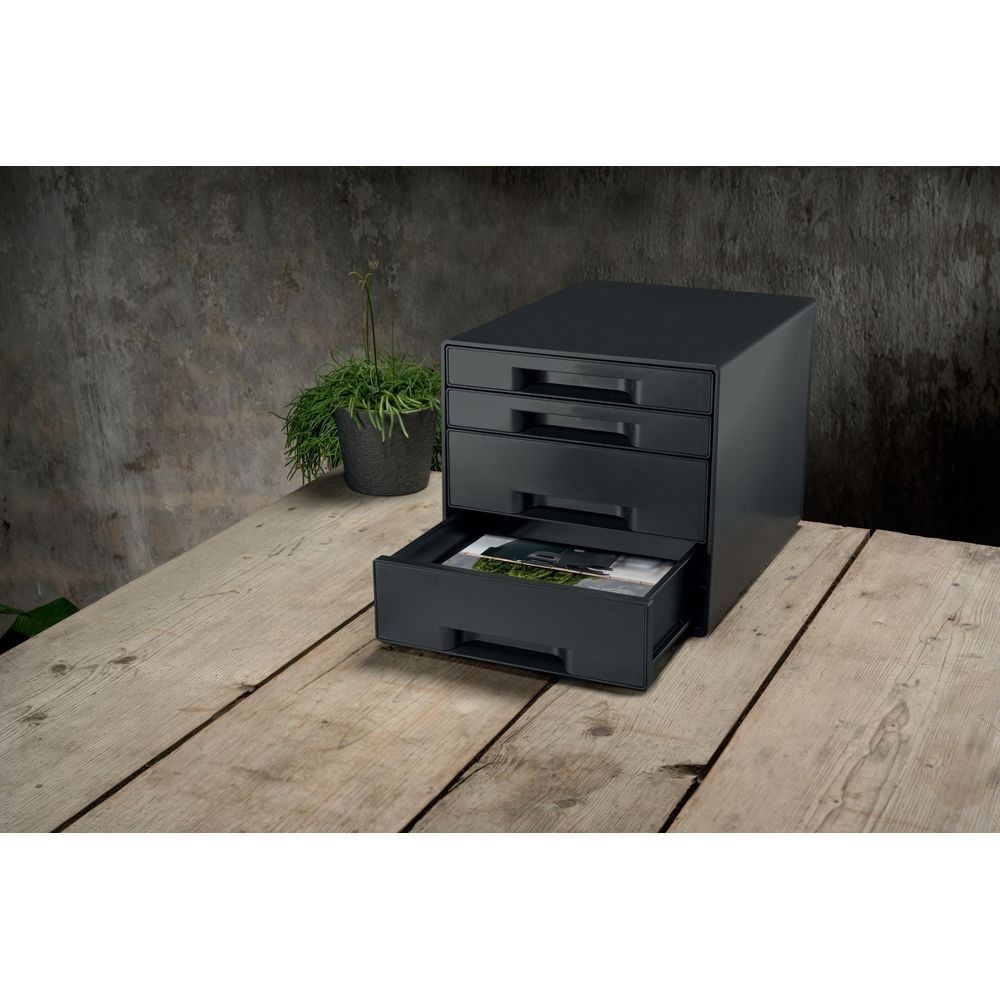 Un archiviatore nero a tre cassetti su un tavolo di legno. Un cassetto è aperto.