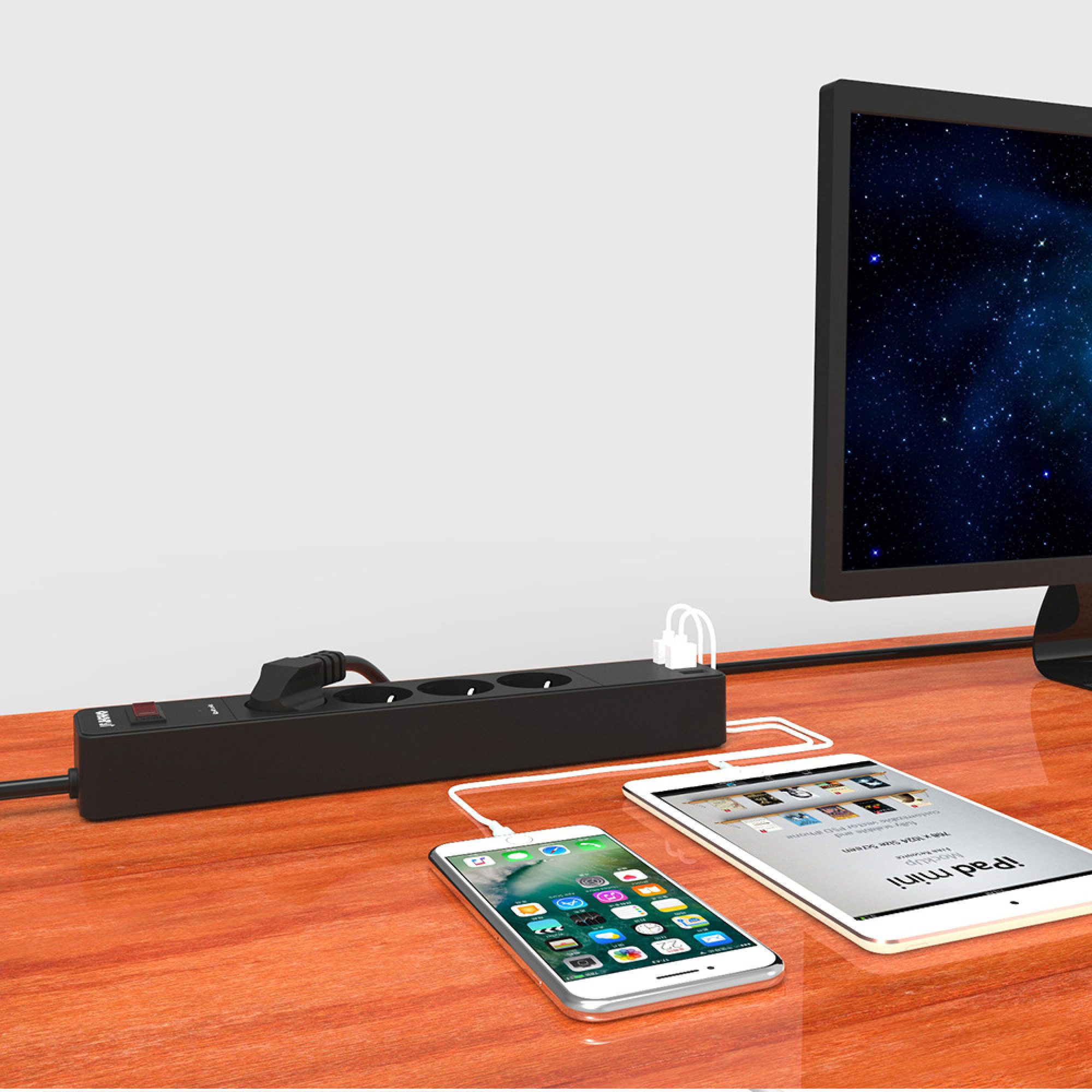 Eine schwarze Steckdosenleiste lädt ein Smartphone und Tablet neben einem Computermonitor.