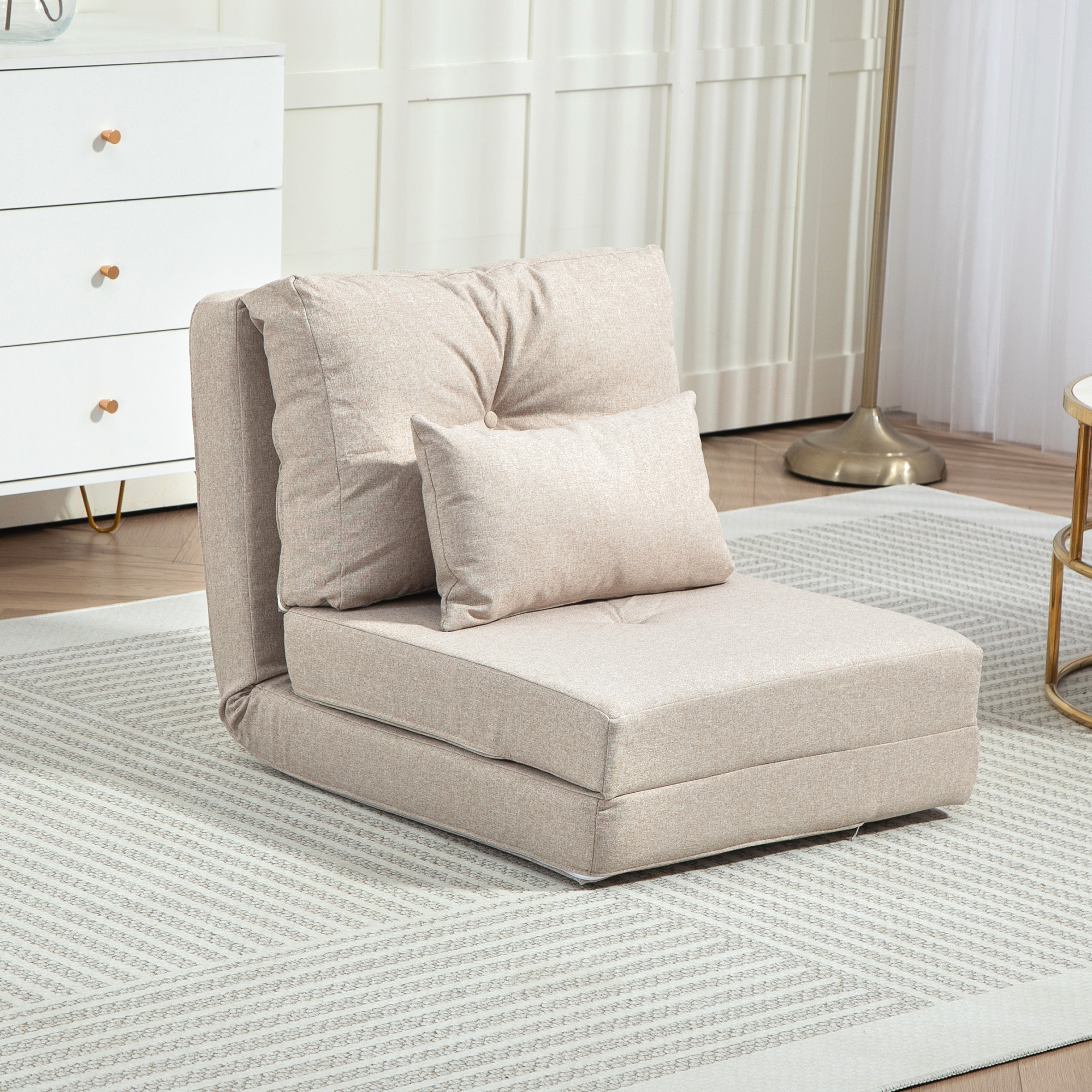 Una silla plegable beige con cojines sobre una alfombra estampada.