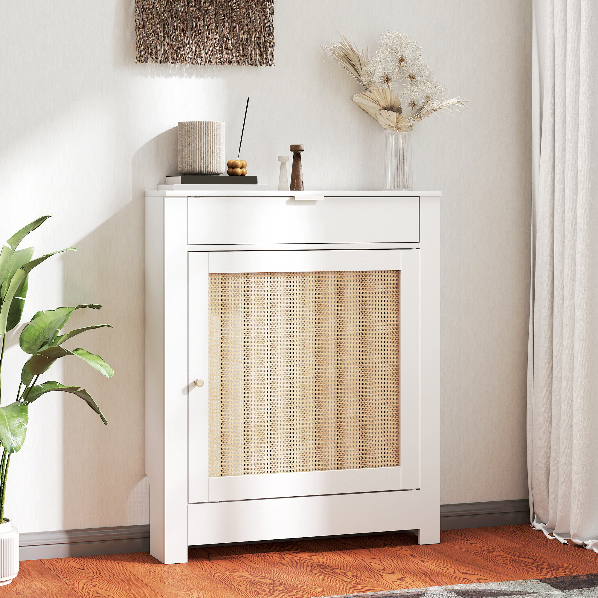 Un armario blanco con puerta de ratán junto a una planta verde.