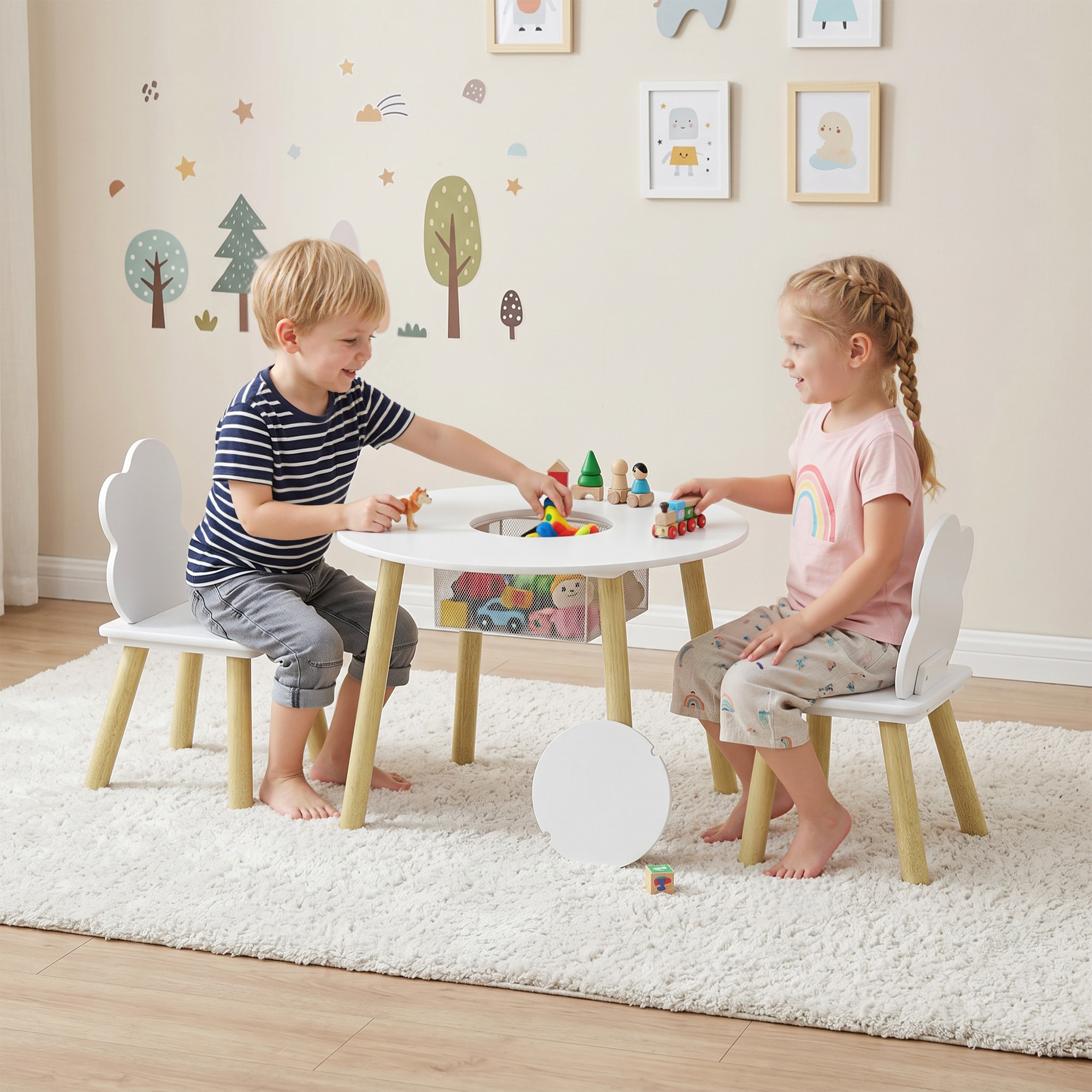 Dos niños juegan en una mesa blanca con juguetes. Decoraciones de pared al fondo.