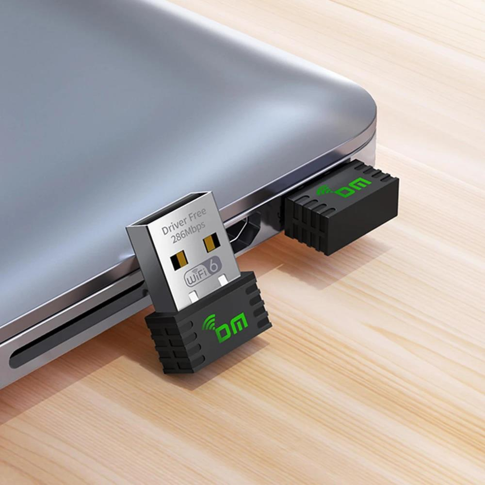 Bir dizüstü bilgisayara takılı iki siyah WiFi 6 USB adaptörü, biri kısmen takılı.