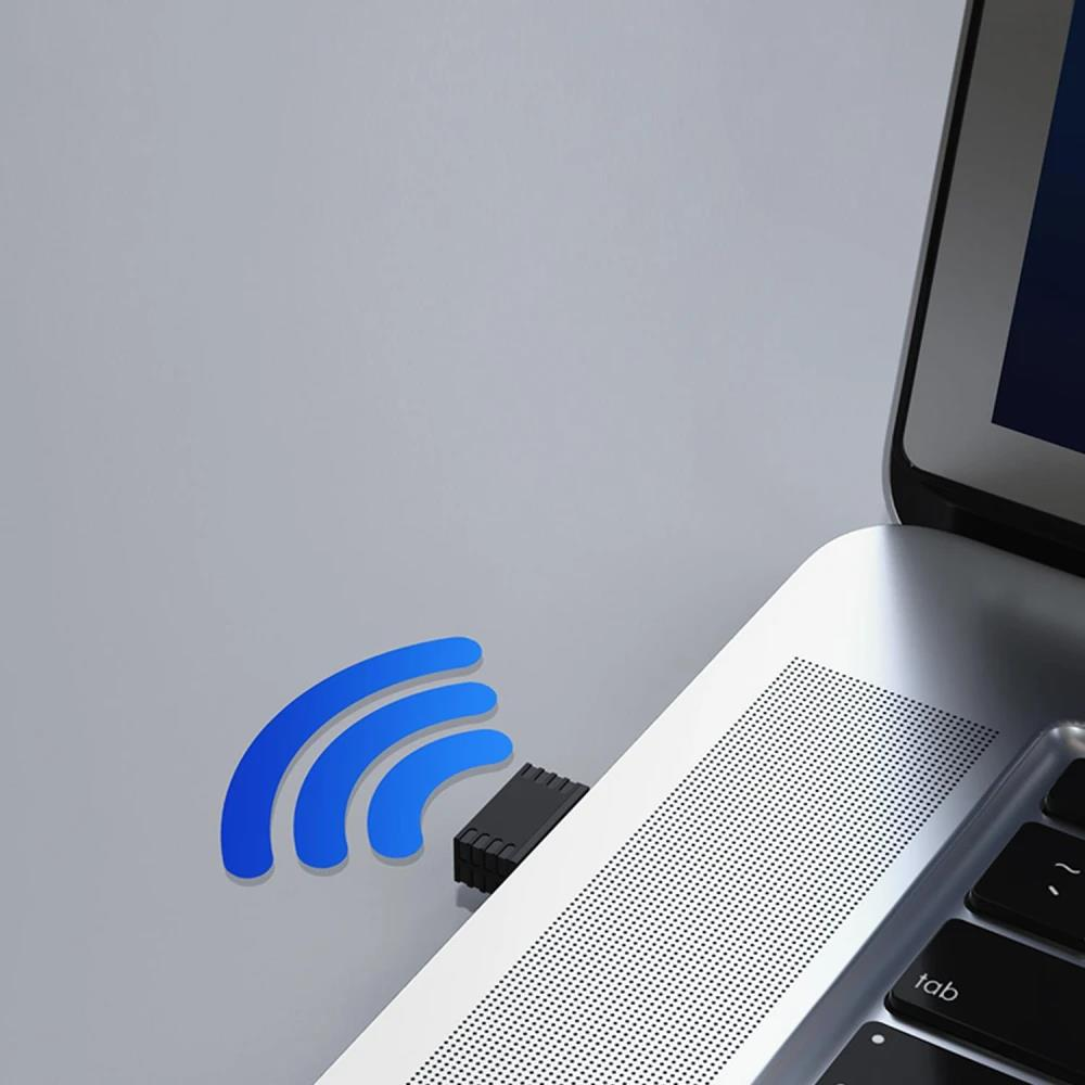 Dizüstü bilgisayarın yanında Wi-Fi sembollü USB dongle.
