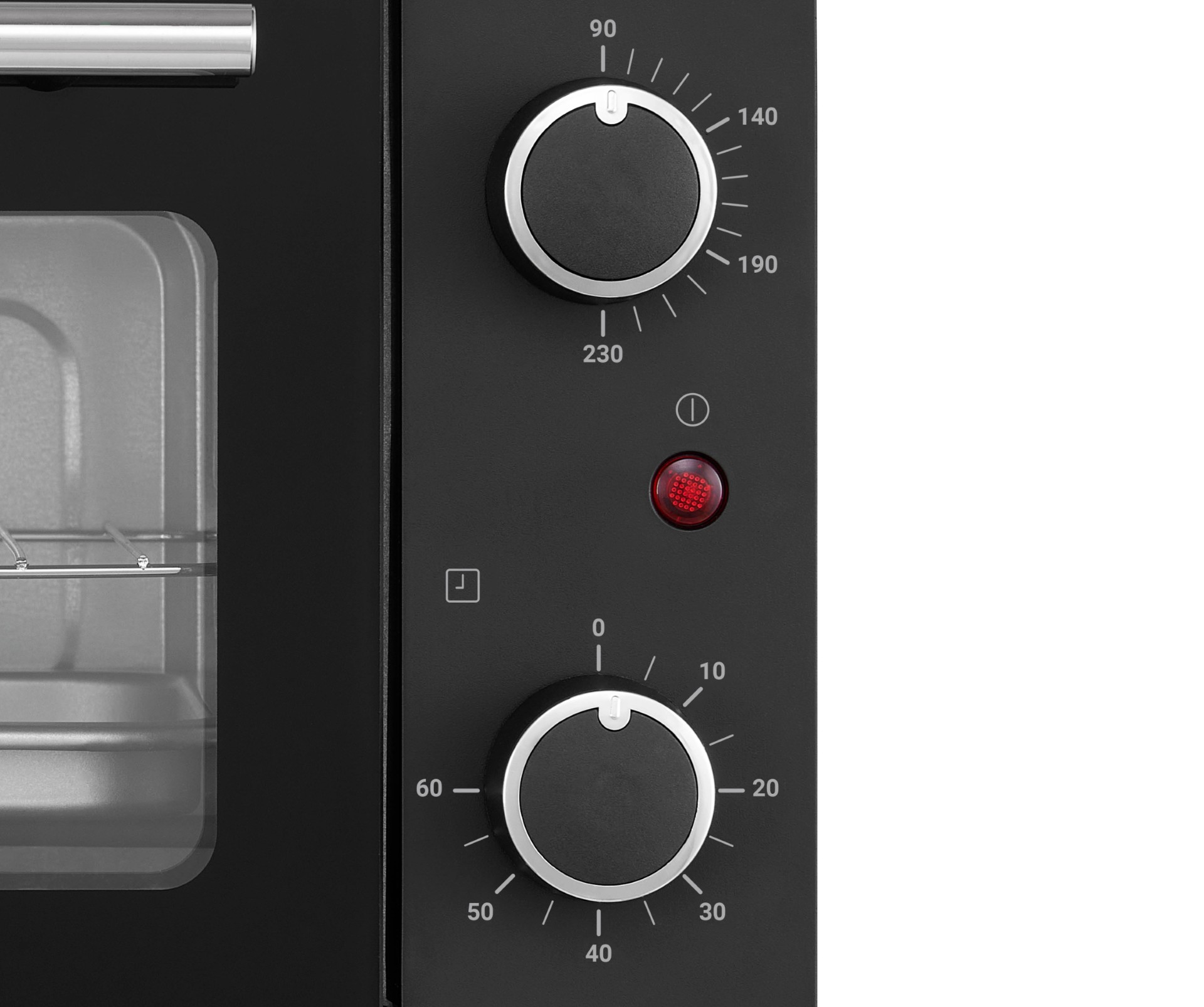 Close-up of a black oven with two control knobs, a red indicator light, and a timer symbol.