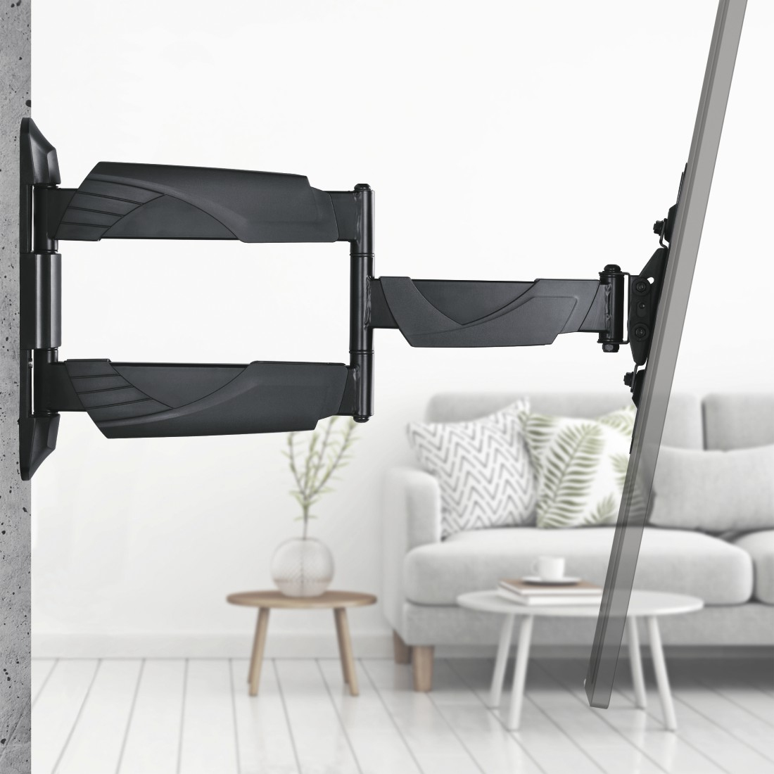 Soporte de pared para TV negro con brazo articulado montado en pared, con sofá.