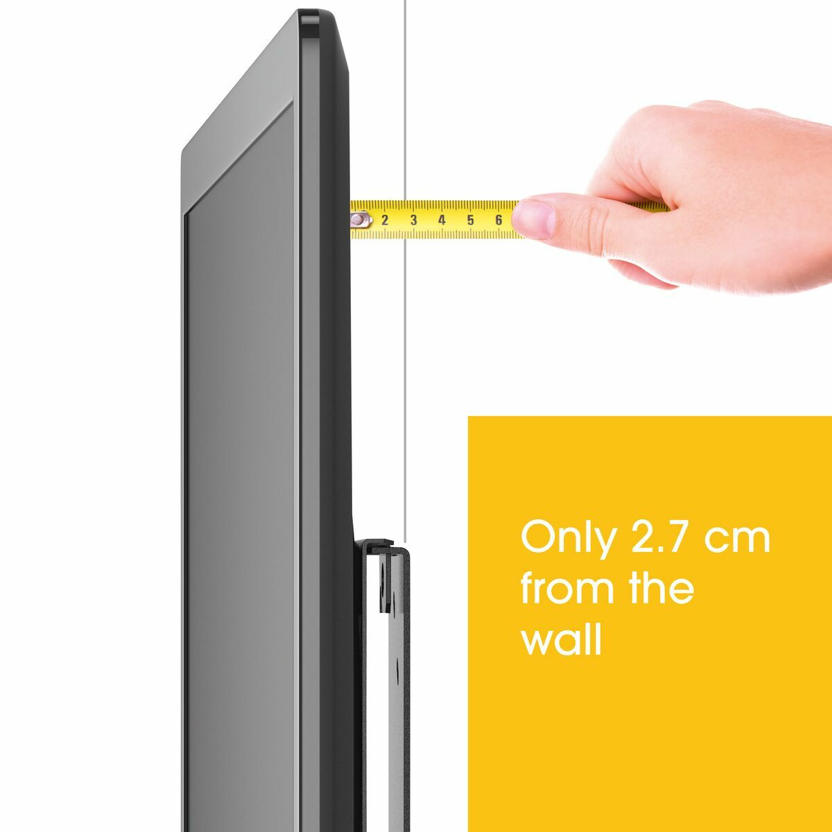 Una cinta métrica muestra 2,7 cm de distancia de un televisor a la pared.