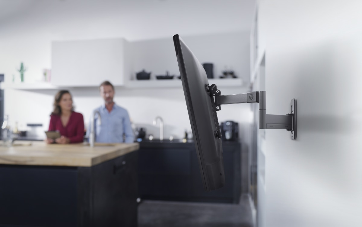 Ein Fernseher ist an einer Wandhalterung in einer modernen Küche montiert.