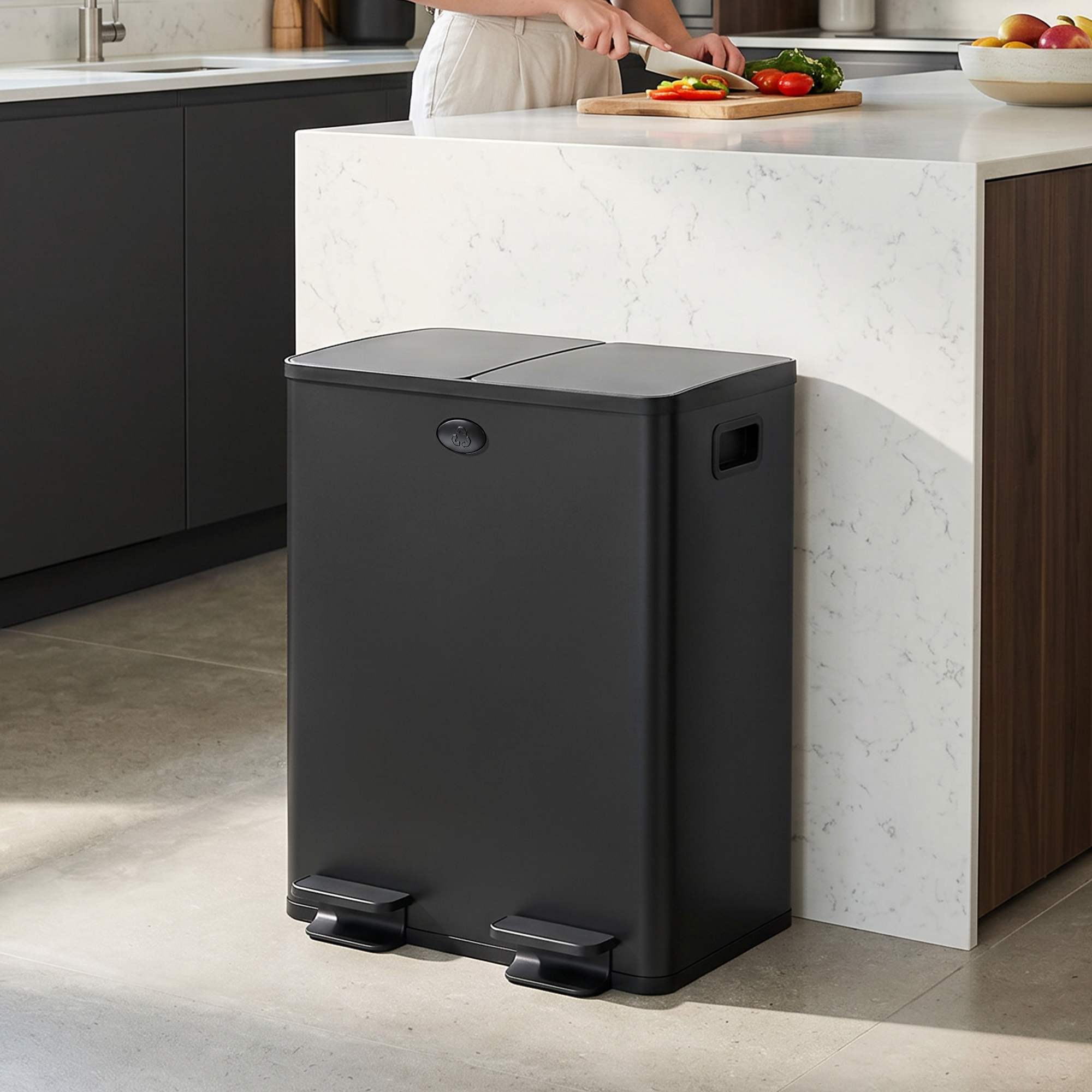 Un cubo de basura negro con dos pedales en una cocina moderna.