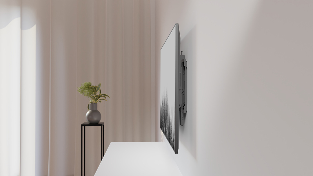 Ein Fernseher mit schwarzem Bild hängt an einer weißen Wand neben einem Vorhang.