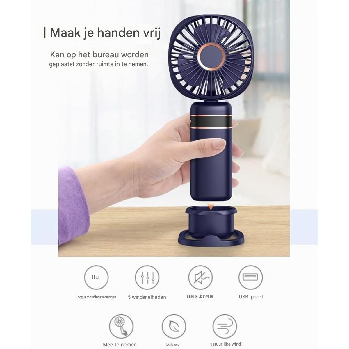 Eine Hand hält einen blauen Handventilator mit bronzefarbenen Akzenten, der auf einem Tisch steht.