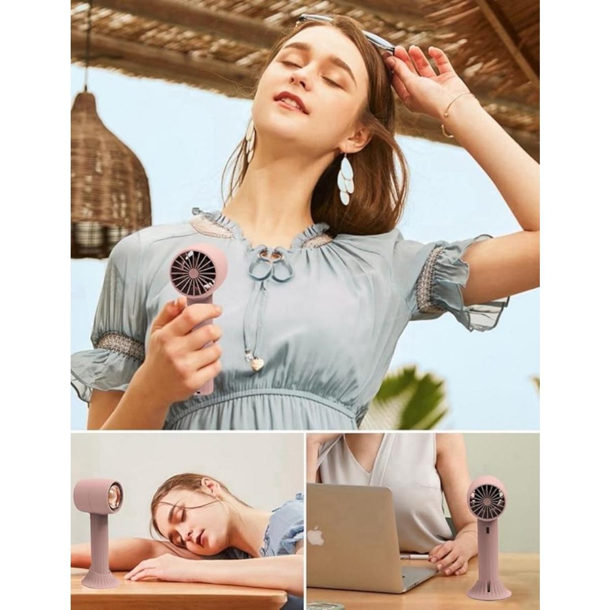 Frau mit kleinem Ventilator, schlafend, am Laptop, im Freien.
