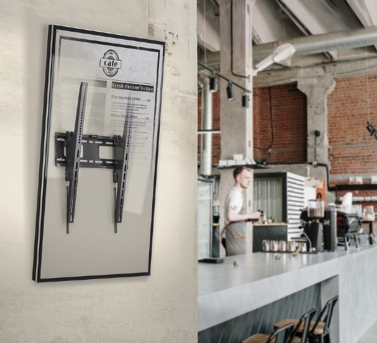 Un cartello con menu appeso a una parete. Accanto, un bar con un barista.