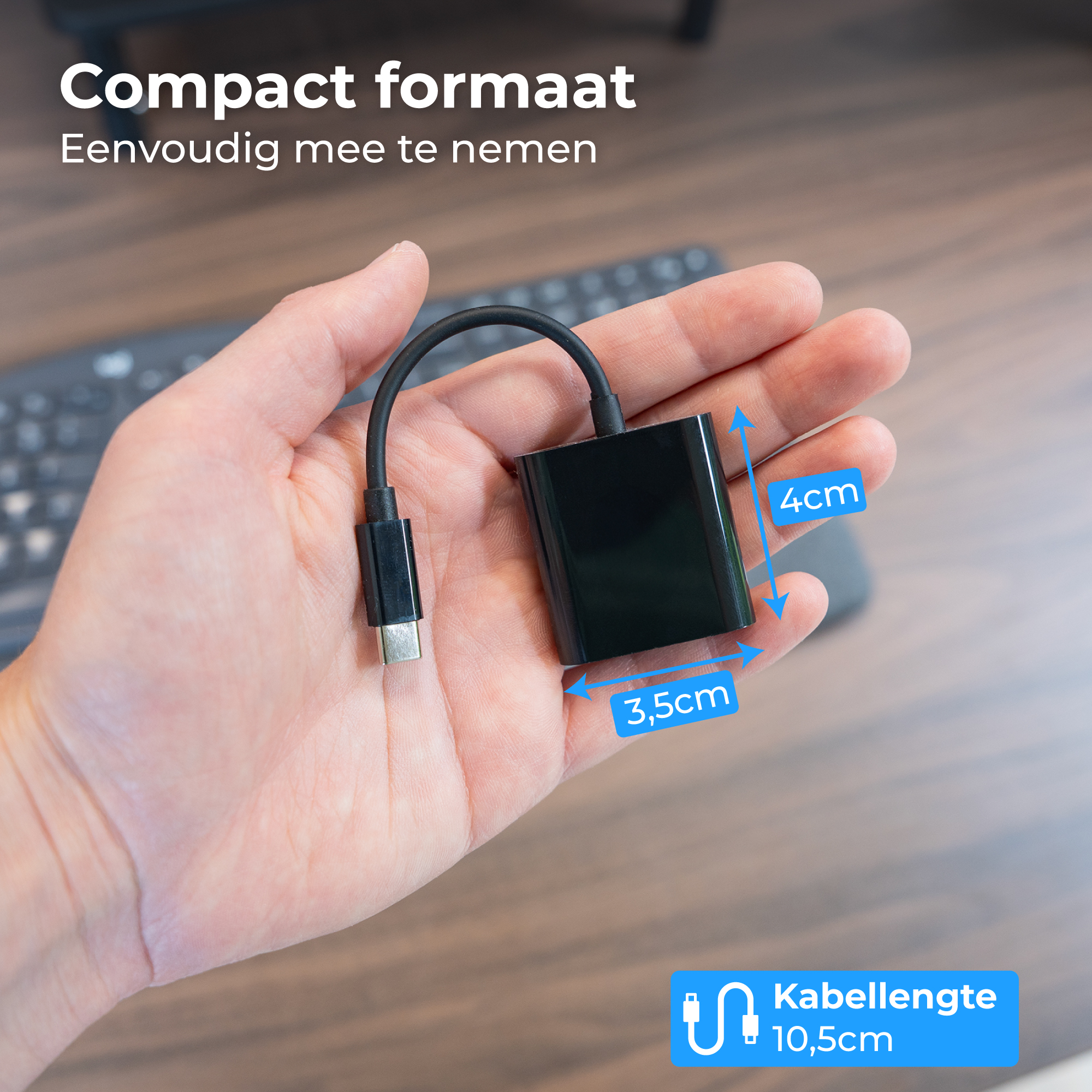 Een hand houdt een zwarte USB-C adapter vast. Afmetingen: 3,5x4cm.