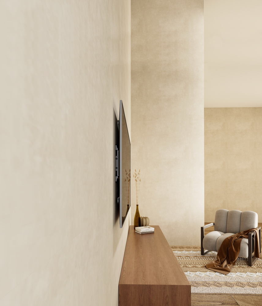 Un soggiorno moderno con TV a parete, console in legno, poltrona e tappeto.