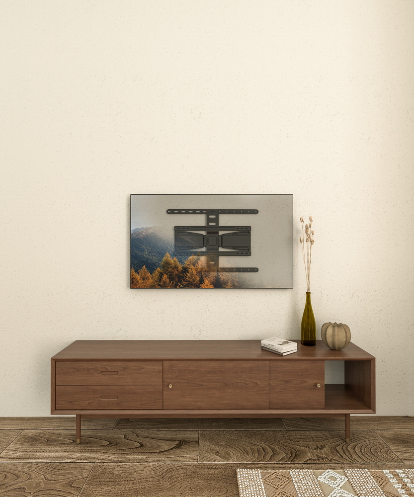 Un supporto da parete TV nero sopra un mobile multimediale marrone con decorazioni.
