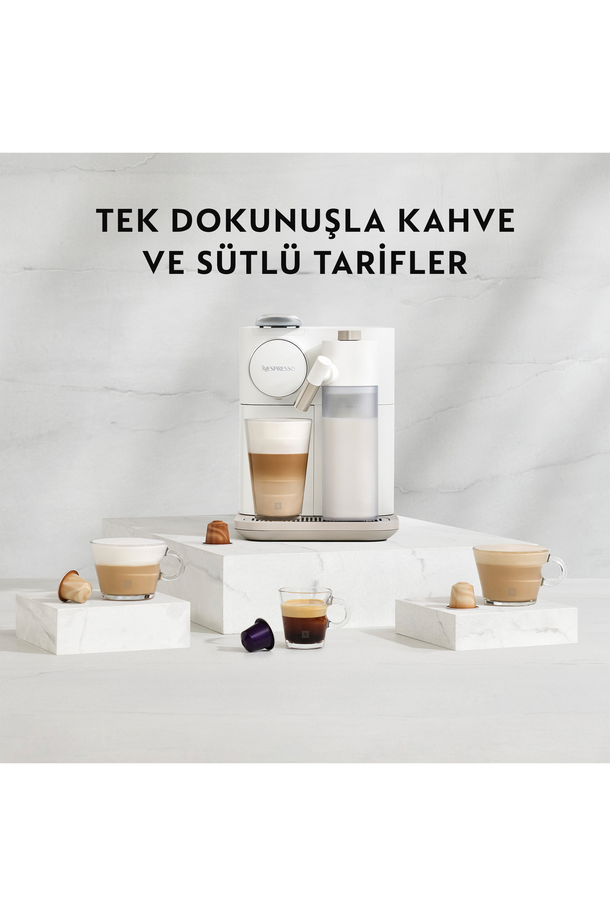 Üç kahve ve kapsül içeren beyaz bir Nespresso kahve makinesi.