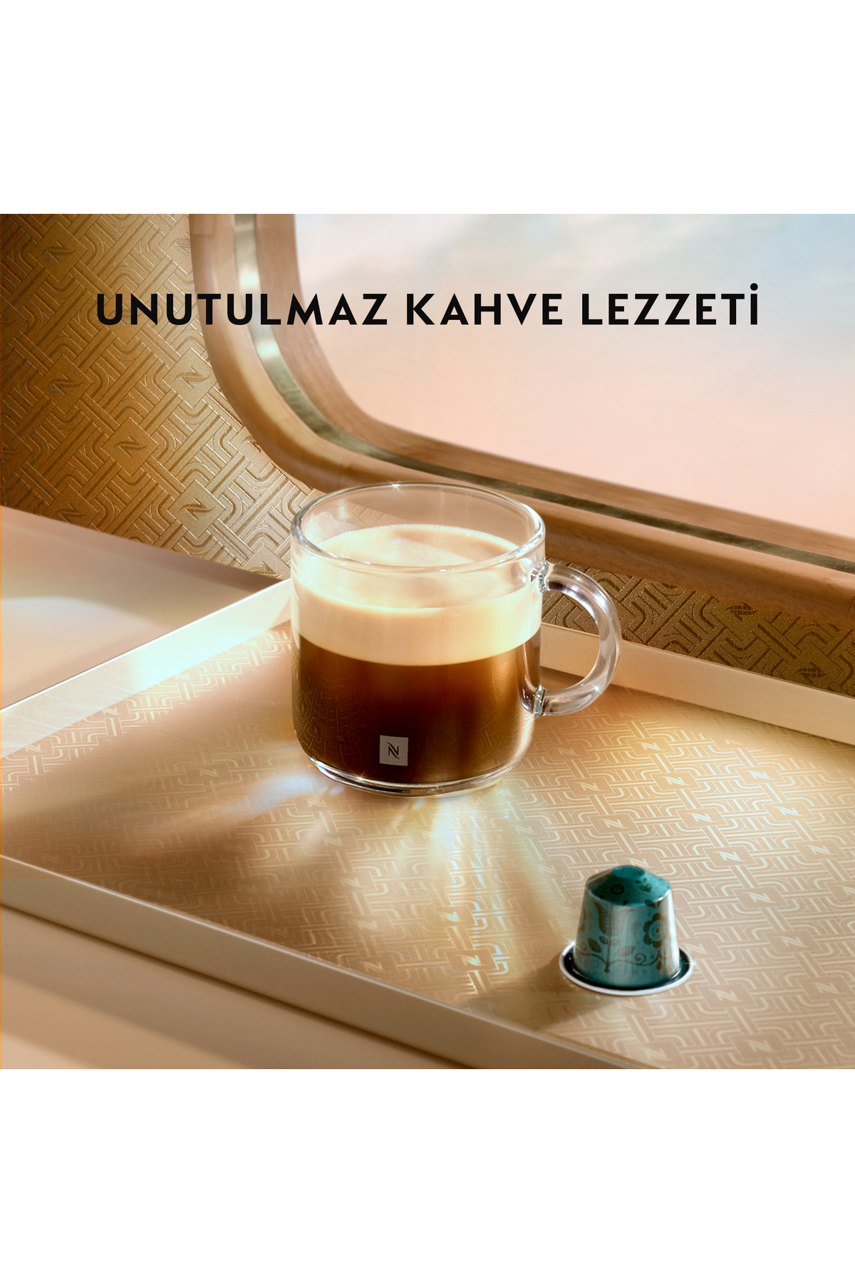 Kremalı bir fincan espresso ve desenli tepside bir kahve kapsülü.