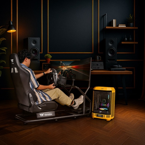 Ein Mann sitzt in einem Rennsimulator mit Lenkrad und Bildschirm.