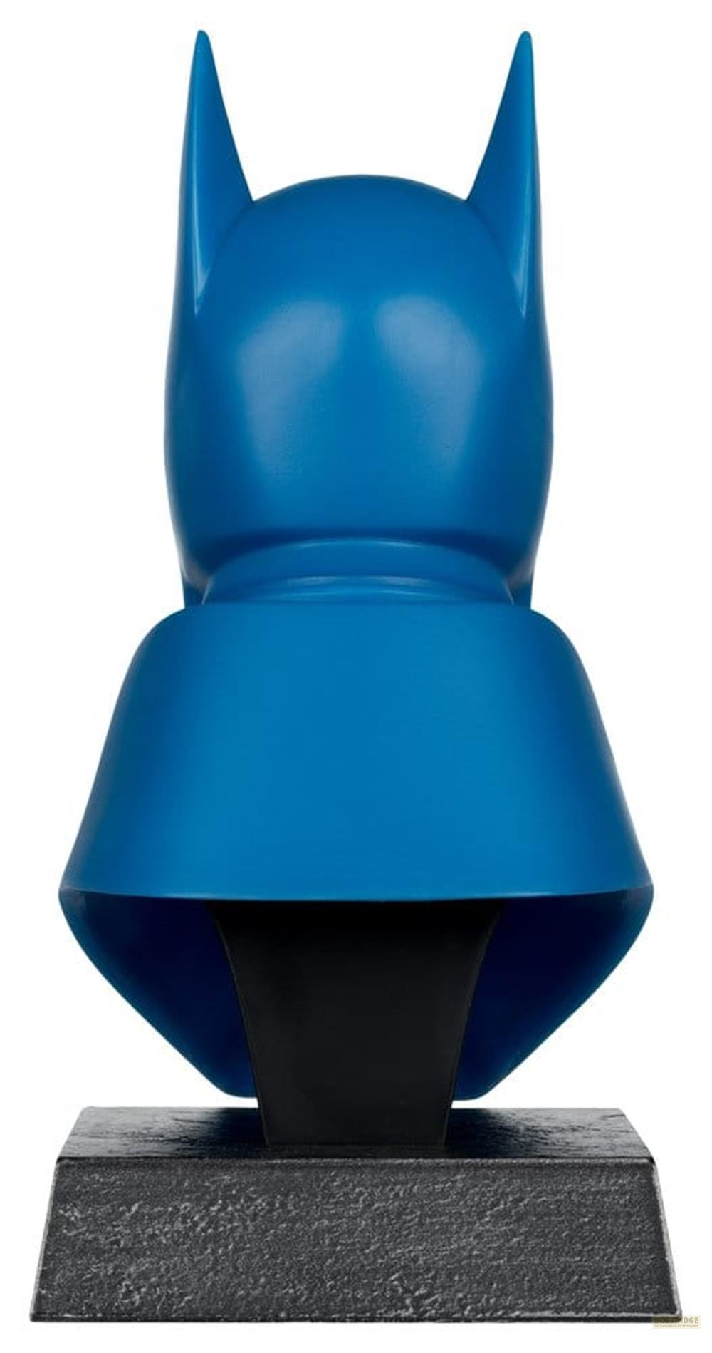 Un busto blu di Batman con accenti neri su una base di pietra.