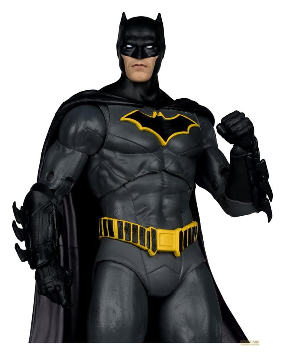 Action figure di Batman in completo grigio con cintura gialla e simbolo del pipistrello.