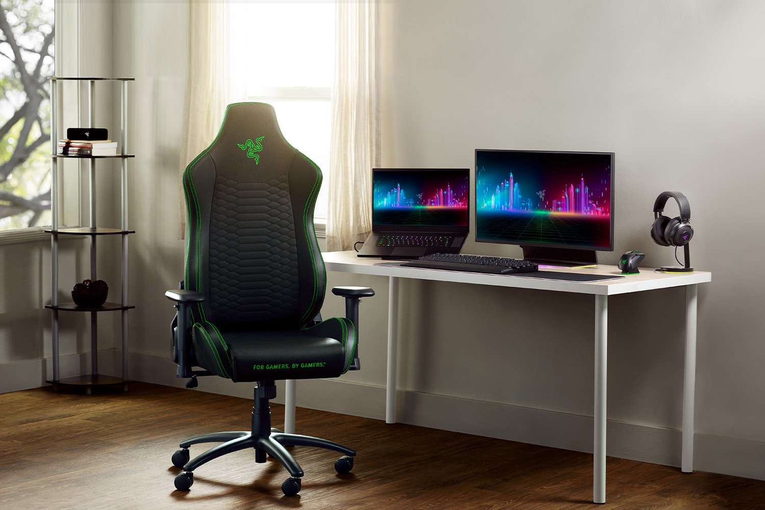 Una sedia da gaming nera con accenti verdi si trova davanti a una scrivania con computer.