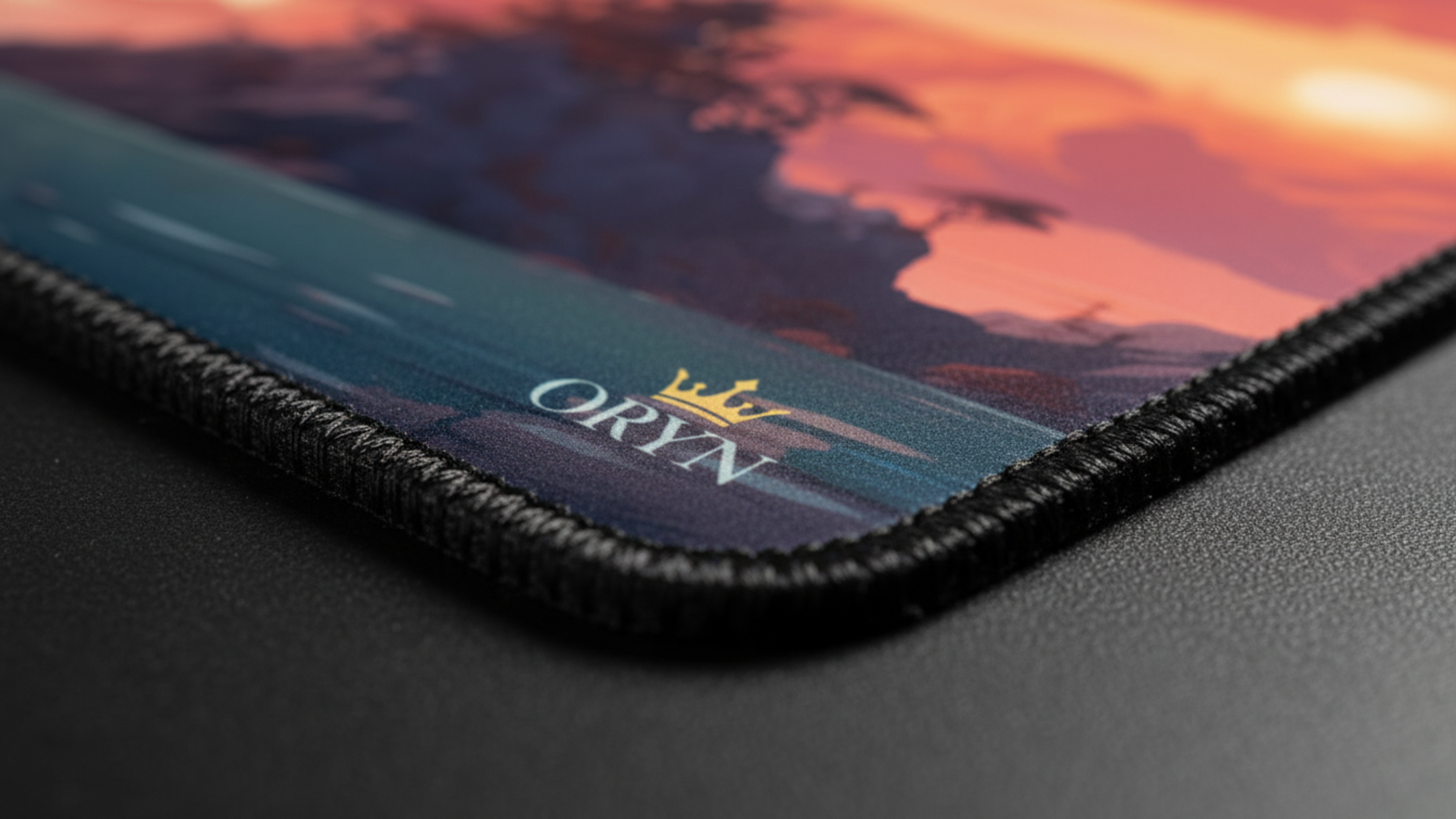 ORYN logosuyla, su üzerinde gün batımı manzaralı bir mousepad.