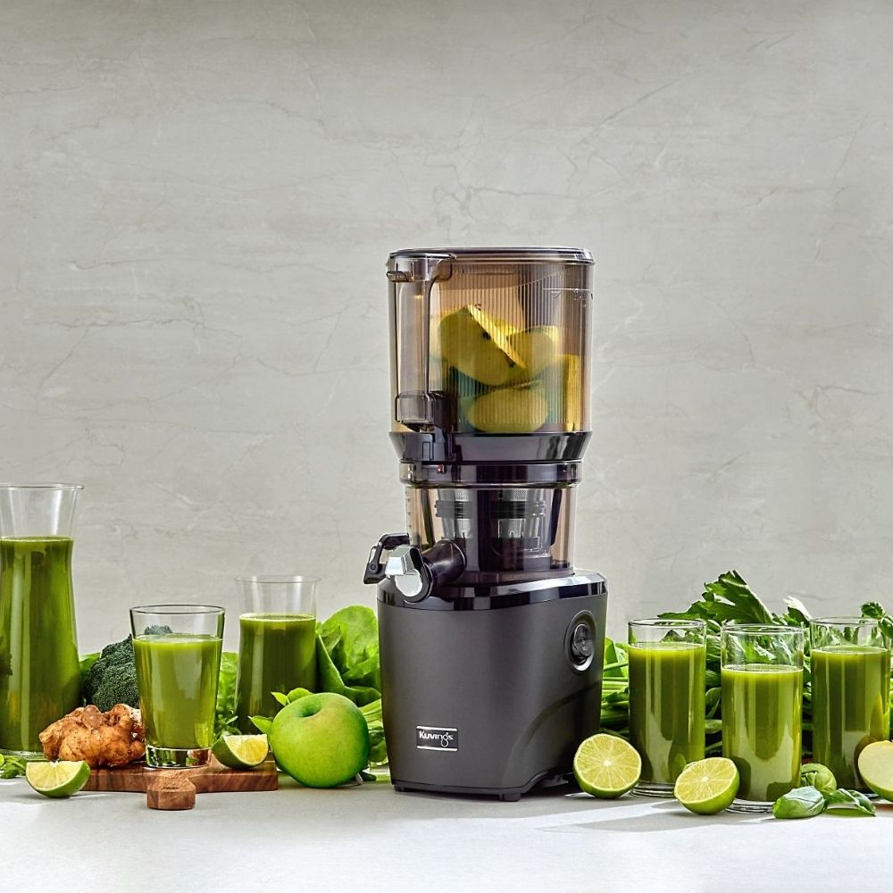 Una licuadora con manzanas, limas, jengibre y jugos verdes.