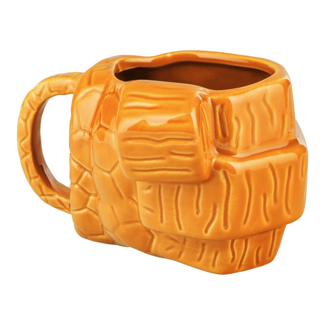 Orangefarbene Keramiktasse mit strukturiertem Design, wie ein Steinblock.