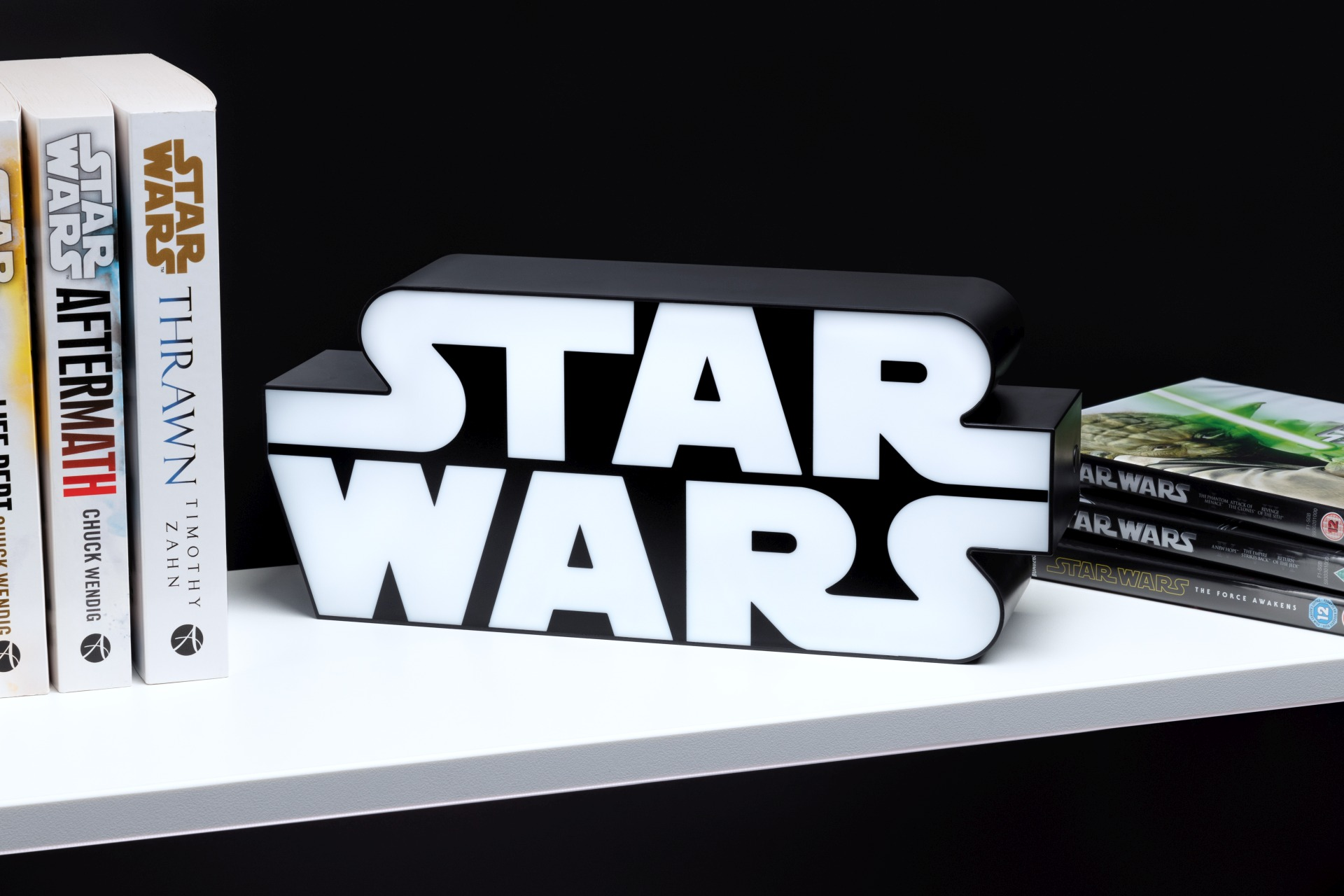 Ein leuchtendes Star Wars Logo steht neben Büchern und DVDs.
