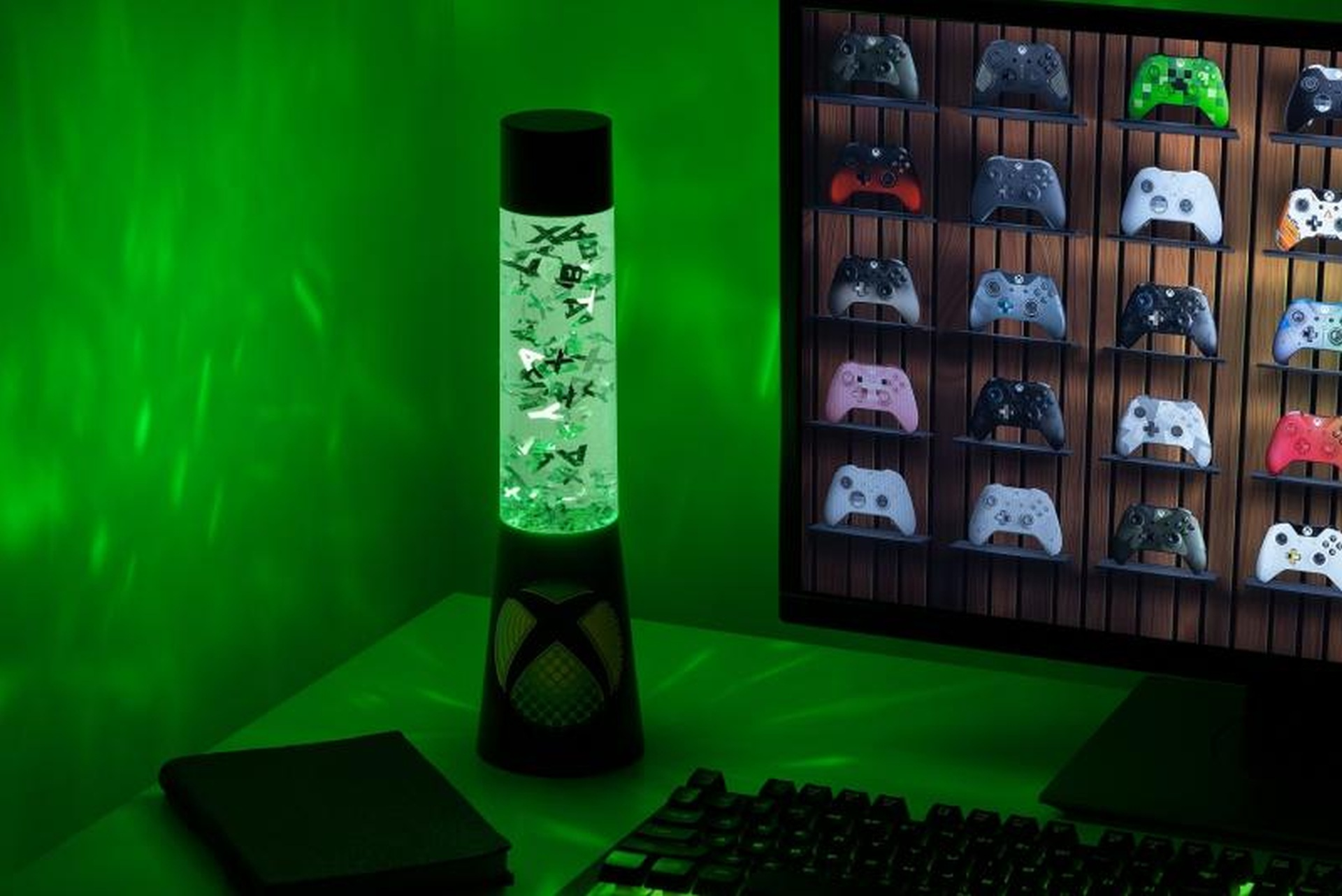 Ein Xbox-Controller-Lampenlicht leuchtet grün. Konsolen-Controller sind auf Regalen ausgestellt.