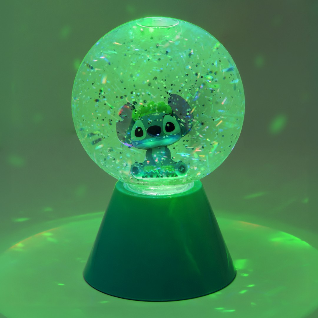 Zielona lampa z figurką Stitch w kuli z brokatem, podświetlona na zielono.