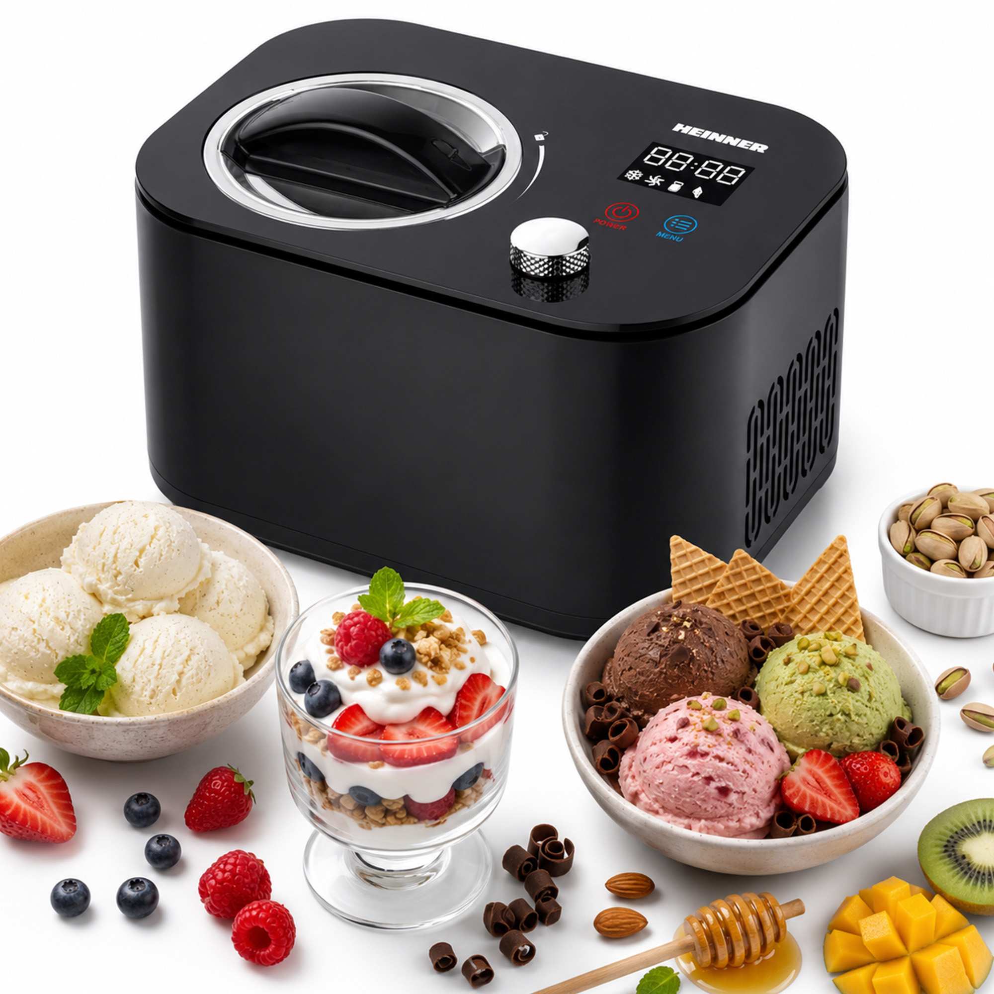 Schwarze Eismaschine neben Schüsseln mit Eis, Beeren und Pistazien.