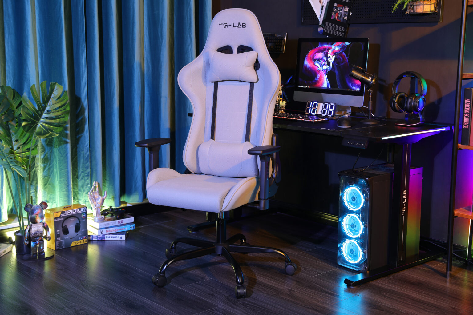 Una silla gamer clara se sienta frente a un escritorio con computadora, audífonos y caja de PC iluminada.